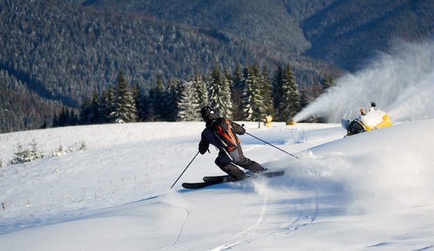 Uomo che scia su piste preparate con neve fresca