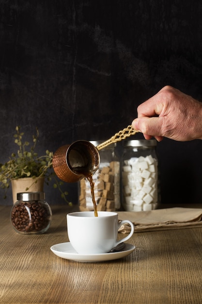 Uomo che serve un caffè turco su un tavolo di legno