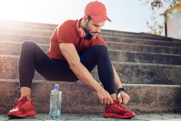 Uomo che si allaccia le scarpe da jogging