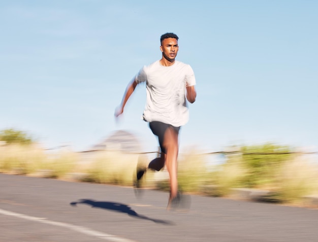 Uomo che si allena e corre su strada nella natura di montagna o all'aperto e atleta che si muove con movimento veloce o allenamento Fitness maschile e corridore negli sport cardio mattutini o obiettivi per il benessere