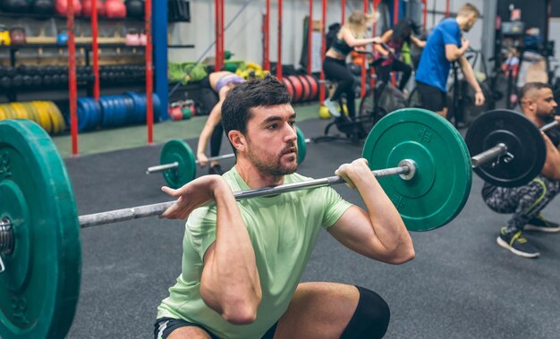 Uomo che si allena sollevando pesi in palestra