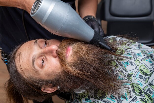 Uomo che si asciuga la barba dal barbiere.