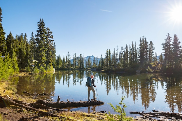 Uomo che si distende al bellissimo lago di montagne.