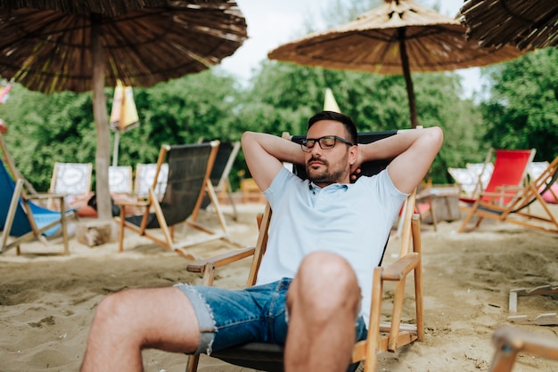 Uomo che si distende su una spiaggia.