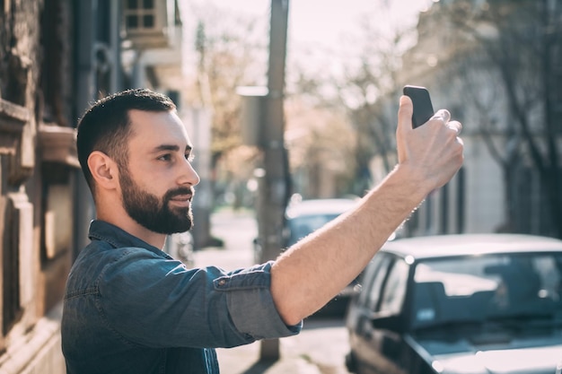 Uomo che si fa un selfie con lo smartphone