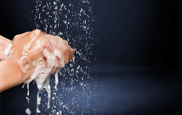 Uomo che si lava le mani in acqua pulita su sfondo blu