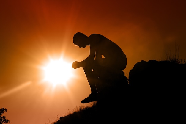 Uomo che si prende una pausa e si rilassa in un prato nella meravigliosa luce calda del tramonto