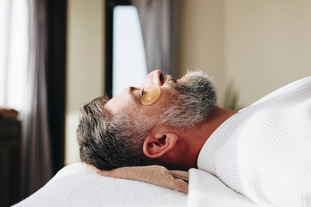 Uomo che si rilassa con un trattamento di maschera d&#39;oro