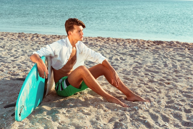 Uomo che si rilassa dopo aver surfato