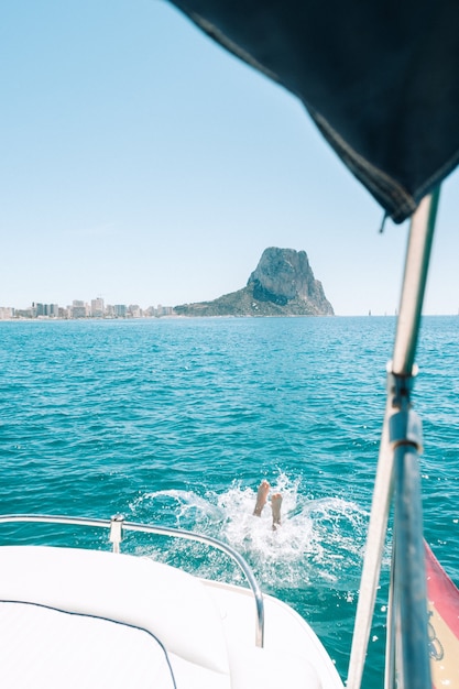 Uomo che si tuffa in acqua dalla barca