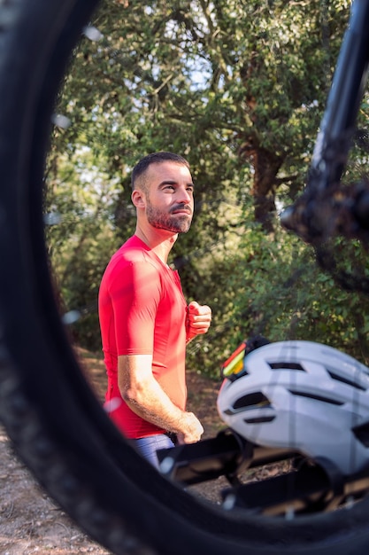 Uomo che si veste accanto al suo furgone per andare in bicicletta