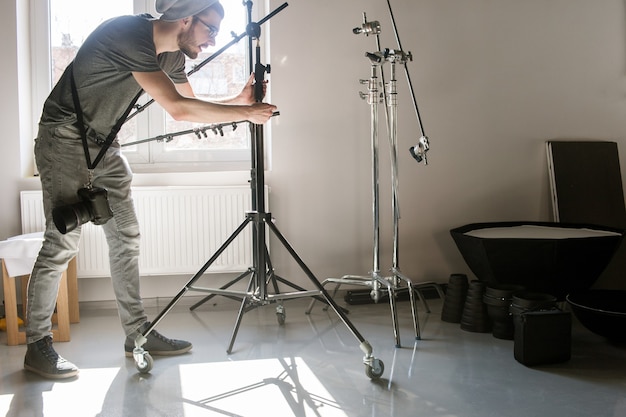 Uomo che sistema il treppiede fotografico