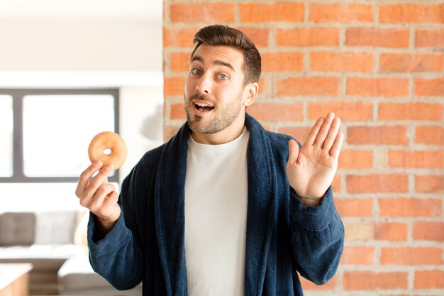 Uomo che sorride allegramente e allegramente, agitando la mano e salutandoti o salutandoti