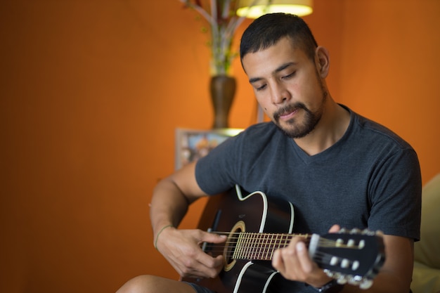 Uomo che suona la chitarra a casa