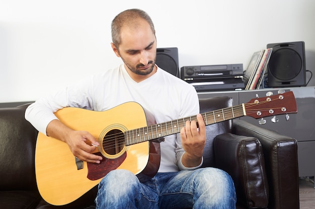 Uomo che suona la chitarra acustica