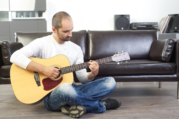 Uomo che suona la chitarra acustica