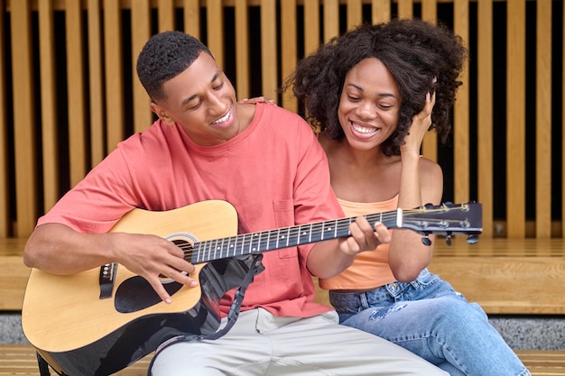 Uomo che suona la chitarra e donna che guarda