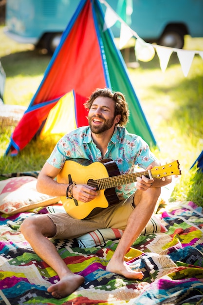 Uomo che suona la chitarra in campeggio