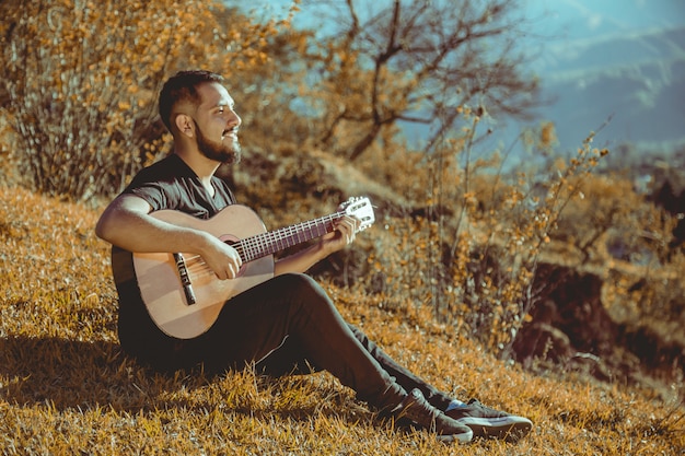 Uomo che suona la chitarra in montagna