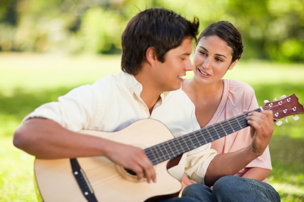 Uomo che suona la chitarra mentre il suo amico lo guarda