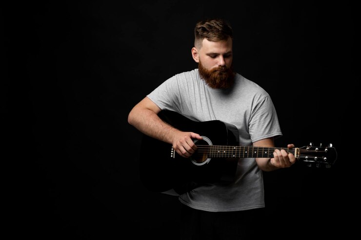 Foto uomo che suona la chitarra su uno sfondo nero