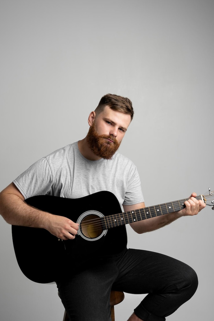 Foto uomo che suona la chitarra sullo sfondo bianco