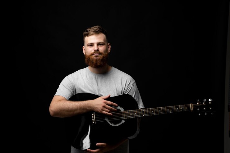 Foto uomo che suona la chitarra sullo sfondo nero