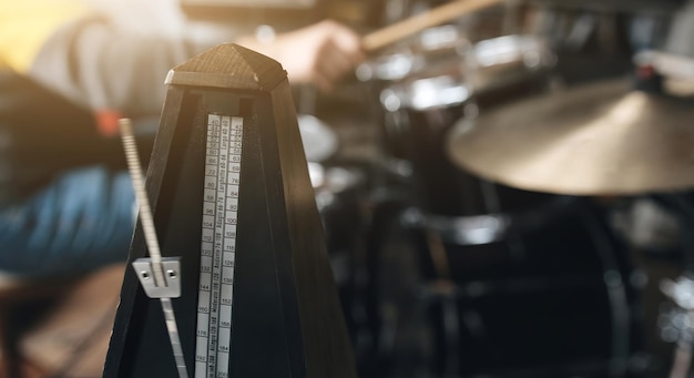 Uomo che suona su tamburi e piatti di piatti in bronzo con bacchette nel musicista dello studio di registrazione durante pe