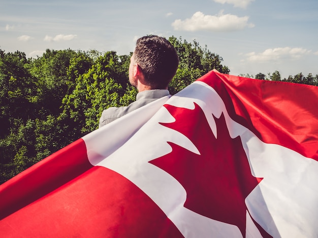 Uomo che sventola una bandiera canadese. festa nazionale