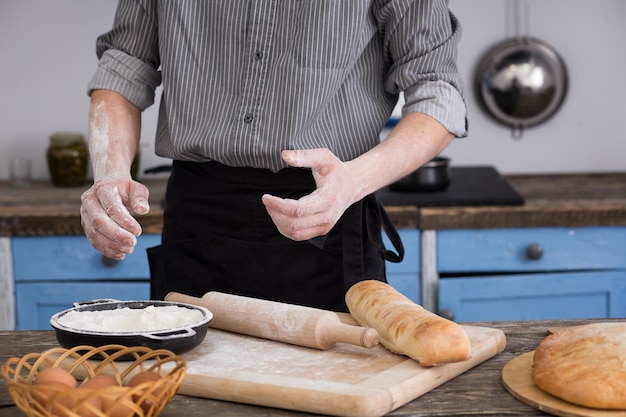 Uomo che taglia il pane in cucina