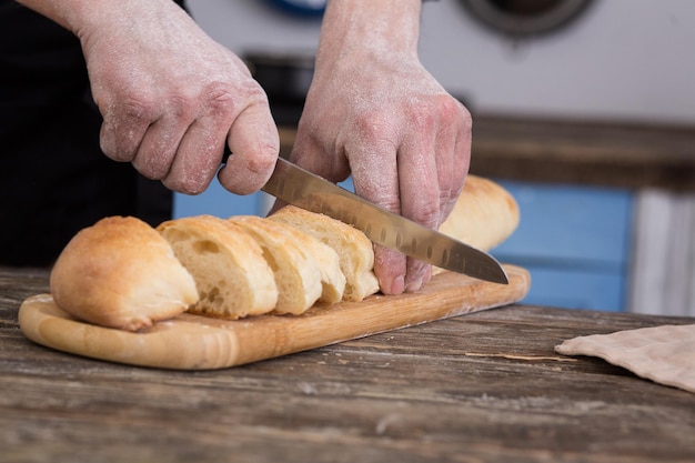 Uomo che taglia il pane in cucina