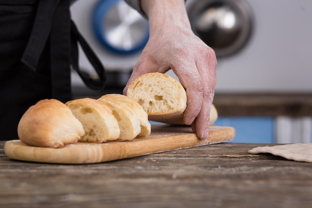 Uomo che taglia il pane in cucina