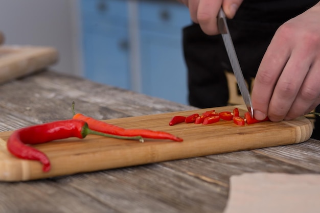 Uomo che taglia il peperoncino piccante