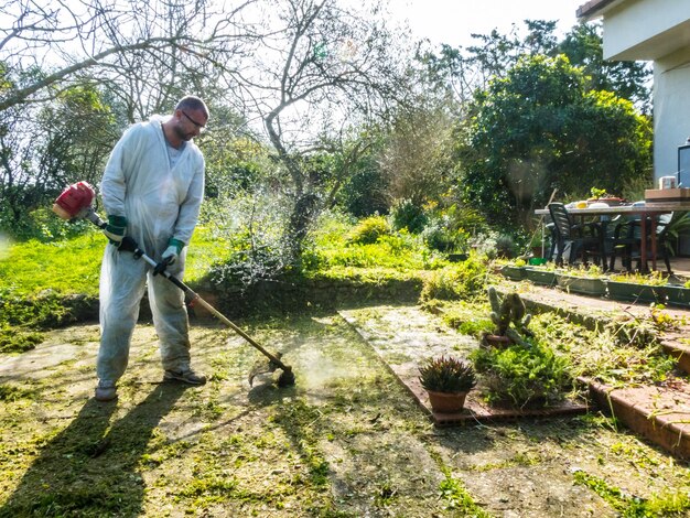 Uomo che taglia l'erba l'erba nel giardino