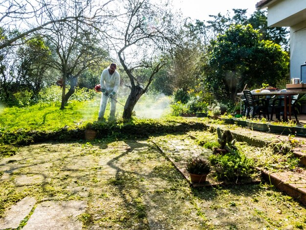 Uomo che taglia l'erba l'erba nel giardino