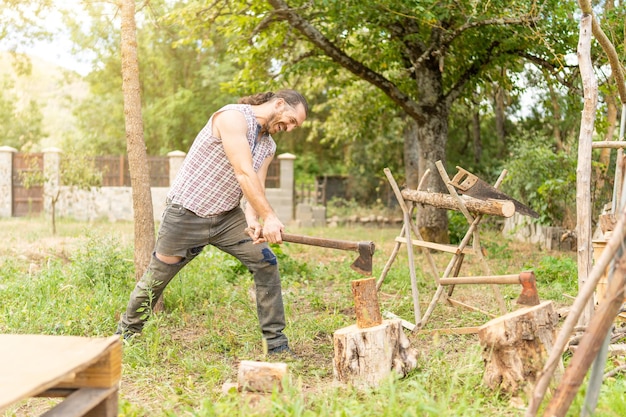 Uomo che taglia la legna con un'ascia all'aperto