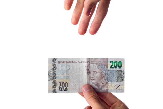 Uomo che tiene banconote da 200 reais isolate su bianco. Soldi brasiliani. pagando.