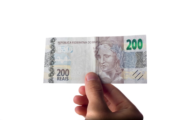 Uomo che tiene banconote da 200 reais isolate su bianco. Soldi brasiliani. pagando.