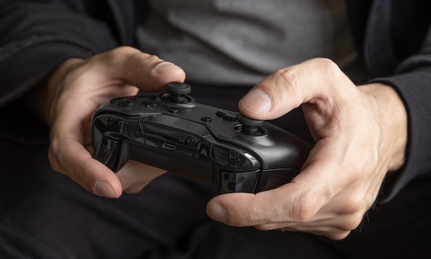 Uomo che tiene il controller di gioco nero - Messa a fuoco selettiva