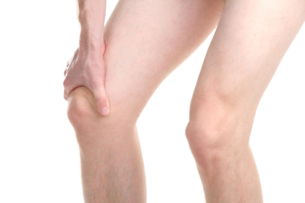 Uomo che tiene il ginocchio dolorante isolato su bianco