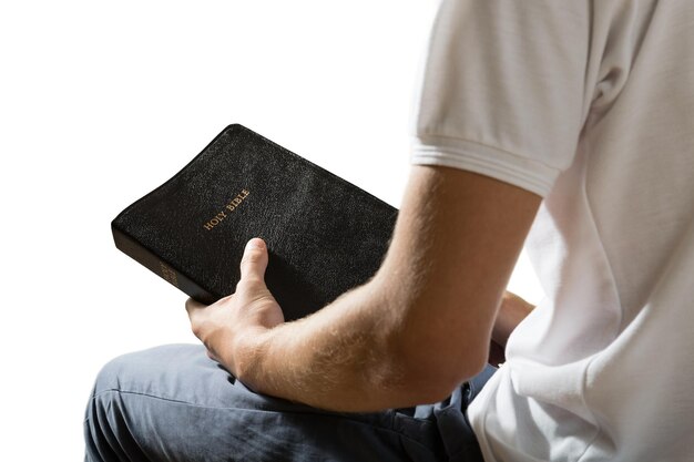 Uomo che tiene il libro biblico isolato su sfondo bianco