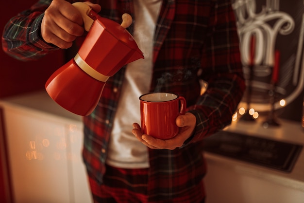 Uomo che tiene la tazza in atmosfera natalizia