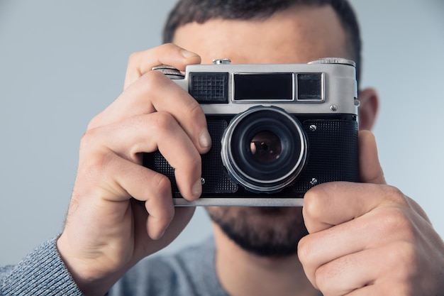 Uomo che tiene macchina fotografica d'epoca