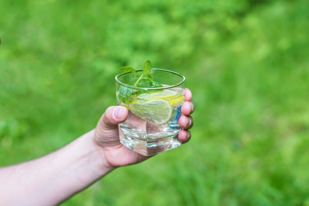 Uomo che tiene un bicchiere d'acqua