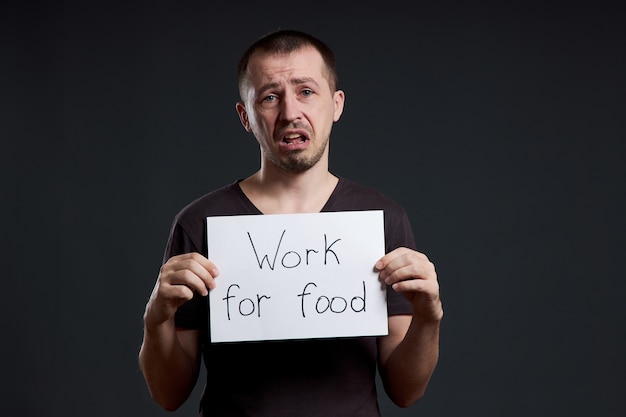 Uomo che tiene un foglio di carta con lavoro di iscrizione per il cibo