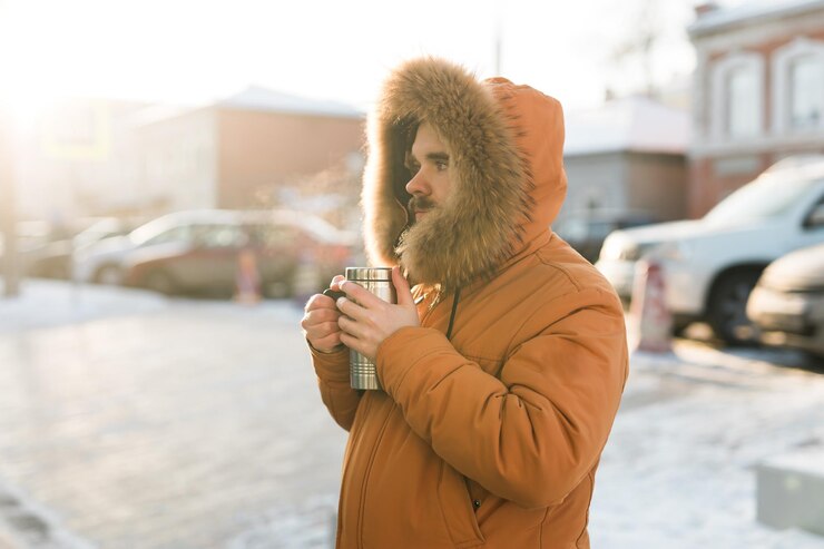 Foto uomo che tiene una bevanda calda sulla strada invernale soleggiata in città calore tranquillità e routine quotidiana all'aperto in