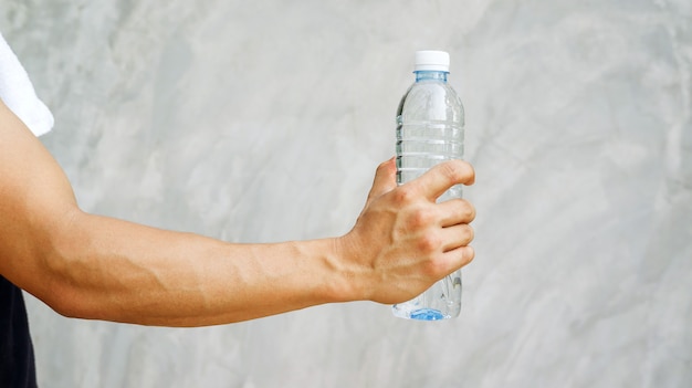 Uomo che tiene una bottiglia d&#39;acqua.