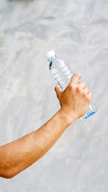 Uomo che tiene una bottiglia d&#39;acqua.