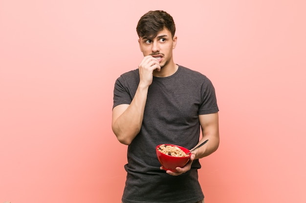 Uomo che tiene una ciotola di cereali in studio