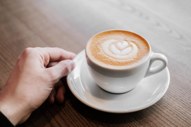 Uomo che tiene una tazza di cappuccino